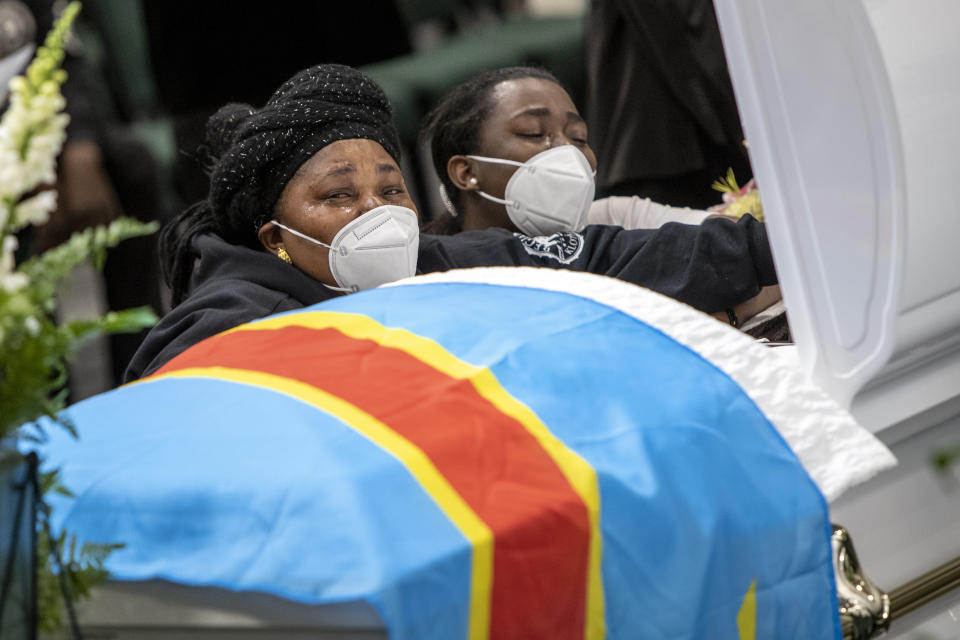 Family and friends cry over the casket with the remains of Patrick Lyoya, including Lyoya's mother, Dorcas Lyoya, left, before the funeral at the Renaissance Church of God in Christ Family Life Center in Grand Rapids, Mich. on Friday, April 22, 2022. The Rev. Al Sharpton demanded that authorities publicly identify the Michigan officer who killed Patrick Lyoya, a Black man and native of Congo who was fatally shot in the back of the head after a struggle, saying at Lyoya's funeral Friday: “We want his name!" (Cory Morse/The Grand Rapids Press via AP)