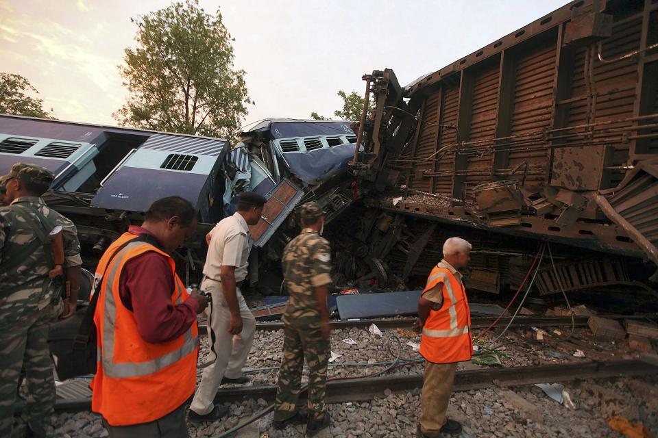 Security personnel and rescue members stand next to damaged coaches of a passenger train after a collision in Khalilabad in the northern Indian state of Uttar Pradesh May 26, 2014. (REUTERS/Stringer)
