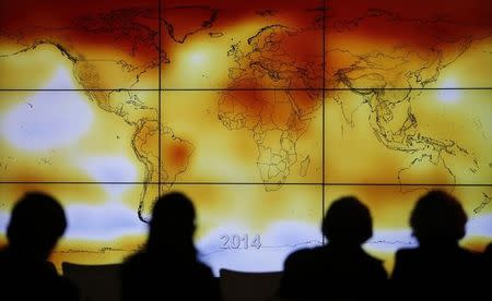 Participants are seen in silhouette as they look at a screen showing a world map with climate anomalies during the World Climate Change Conference 2015 (COP21) at Le Bourget, near Paris, France, December 8, 2015. REUTERS/Stephane Mahe