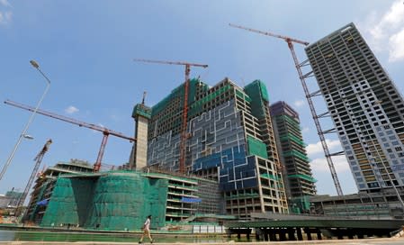 A man walks past the construction sites of the new apartments and luxury hotels in capital city Colombo