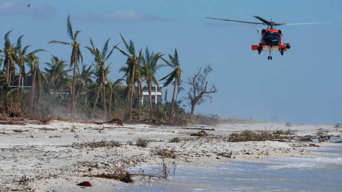 A U.S. Coast Guard helicopter prepares to land on the beach to ferry people off the island, in the wake of Hurricane Ian, Friday, Sept. 30, 2022, on Sanibel Island, Fla. (AP Photo/Steve Helber)