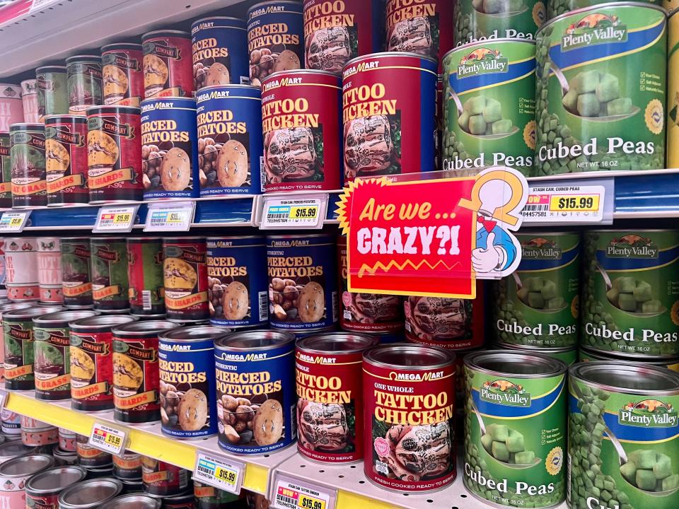 Green, red, and blue stash cans with labels like cubed peas, tattoo chicken, and pierced potatoes.