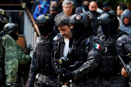 Dámaso López, apodado "el licenciado", es escortado por policías en Ciudad de México. 2 de mayo de 2017. Fuerzas federales de México arrestaron el martes al capo de la droga Dámaso López, quien presuntamente estaba involucrado en una sangrienta lucha para reemplazar a Joaquín "El Chapo" Guzmán al frente del cártel de Sinaloa, considerada una de las mayores organizaciones del narcotráfico mundial. REUTERS/Carlos Jasso