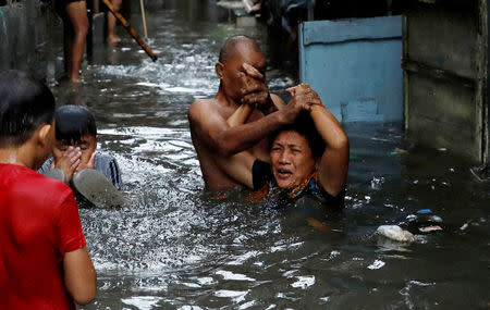 Residents wade along floodwaters in Quezon City, Metro Manila as a storm sweeps across the main Luzon island, Philippines, September 12, 2017. REUTERS/Dondi Tawatao