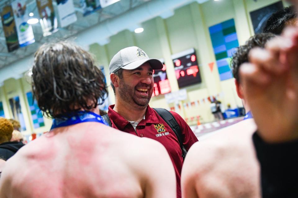 Rocky Mountain head coach Joel Thompson smiles with swimmers after the 5A State Championships at Veterans Memorial Aquatics Center in Thornton, Colo., on Friday, May 12, 2023.