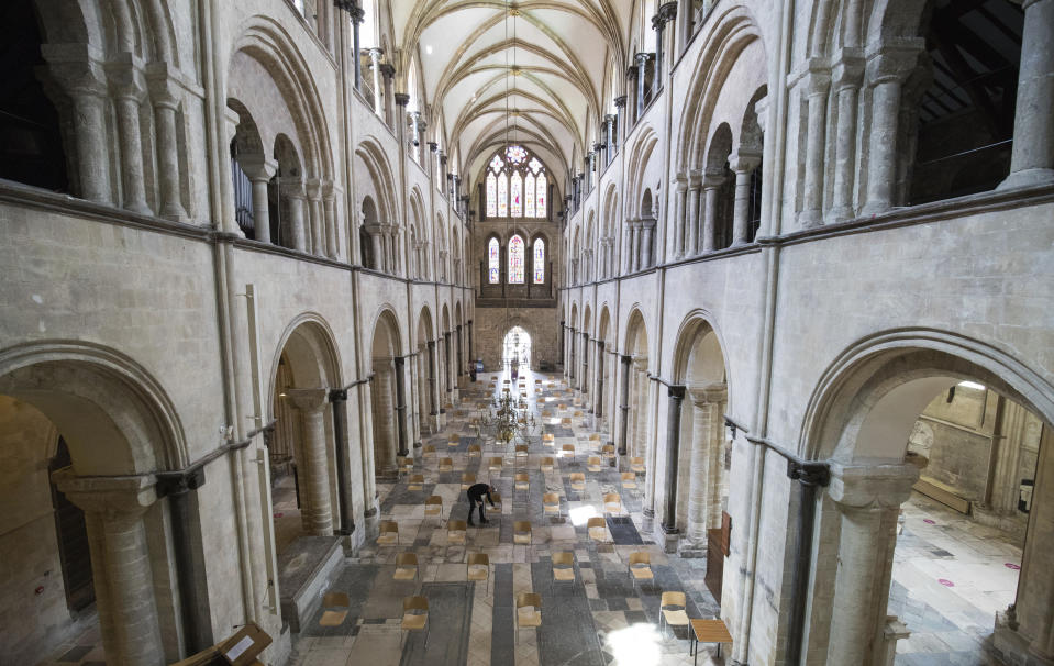 Senior Verger Luke Marshall cleans chairs that have be positioned to allow for social distancing, at Chichester Cathedral as they prepare to reopen for public worship on July 5, as further coronavirus lockdown restrictions are lifted in England, in Chichester, England, Thursday July 2, 2020. (Andrew Matthews/PA via AP)