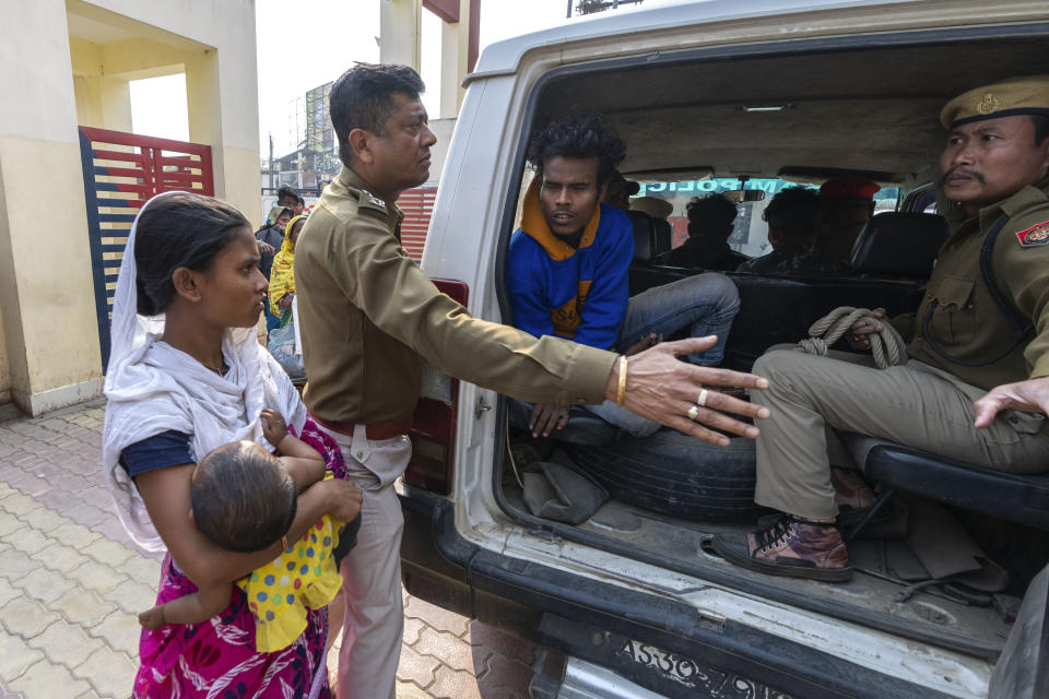 Nureja Khatun, 19, holding her 6 months old baby, requests police to release her husband Akbor Ali, sitting in police van as they take him to court, in Morigaon district of Indian northeastern state of Assam, Saturday, Feb. 11, 2023. Khatun's husband is one among more than 3,000 men, including Hindu and Muslim priests, who were arrested nearly two weeks ago in the northeastern state of Assam under a wide crackdown on illegal child marriages involving girls under the age of 18. (AP Photo/Anupam Nath)