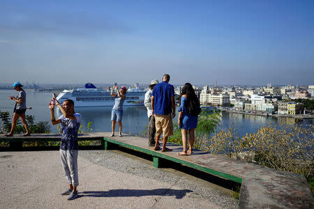 Tourists take pictures in Havana, Cuba, April 11, 2018. REUTERS/Alexandre Meneghini