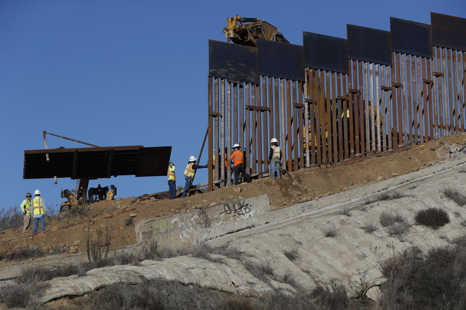 Workers add new sections to the U.S. border wall in Tijuana, Mexico, on Saturday