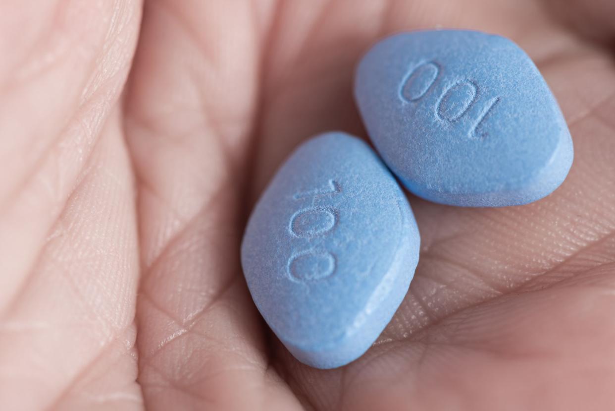 Two blue pills viagra in male hand. Medicine concept of men health, medication for erection, treatment of erectile dysfunction Close up