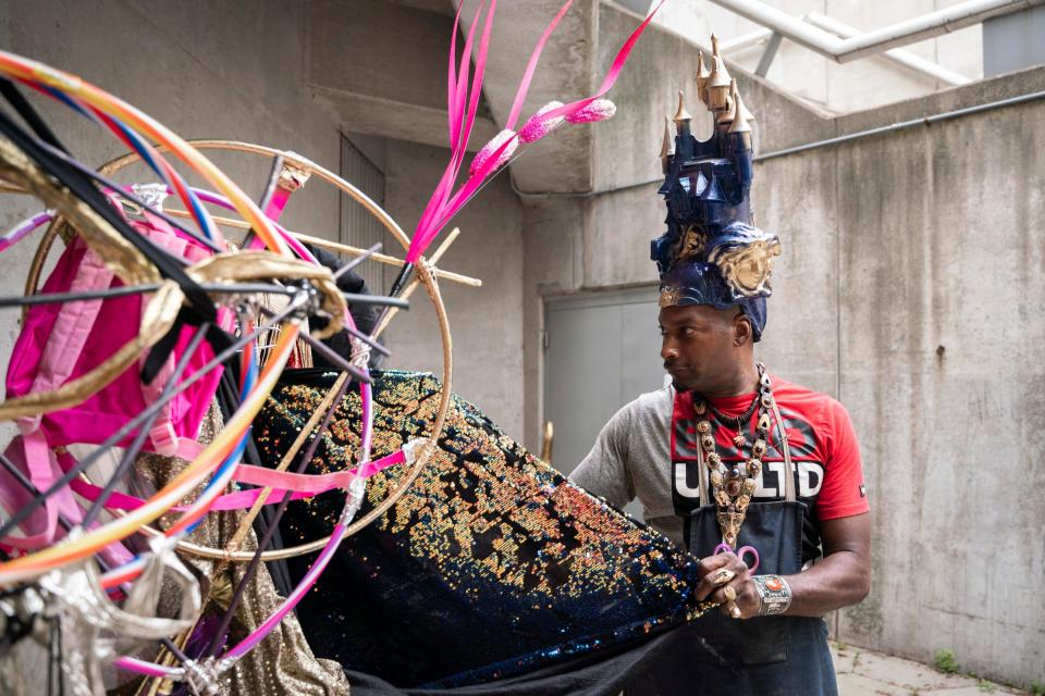 Detroit resident Sevin McClure, 50, prepares his costume designs before performing on stage during the official opening ceremony for The Wright's 39th African World Festival at Hart Plaza in Detroit on Friday, July 15, 2022. "The castle crown is a representation of having a castle mind, which means you are open to experiencing royalty," said McClure.