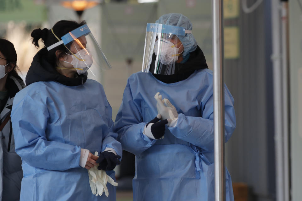 Medical workers wearing protective gears in the sub-zero temperatures talk at coronavirus testing site in Seoul, South Korea, Monday, Dec. 21, 2020. (AP Photo/Lee Jin-man)