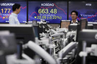 Currency traders work at the foreign exchange dealing room of the KEB Hana Bank headquarters in Seoul, South Korea, Tuesday, Jan. 28, 2020. Asian shares continued to fall Tuesday, dragged down by worries about an outbreak of a new virus in China that threatens global economic growth. (AP Photo/Ahn Young-joon)