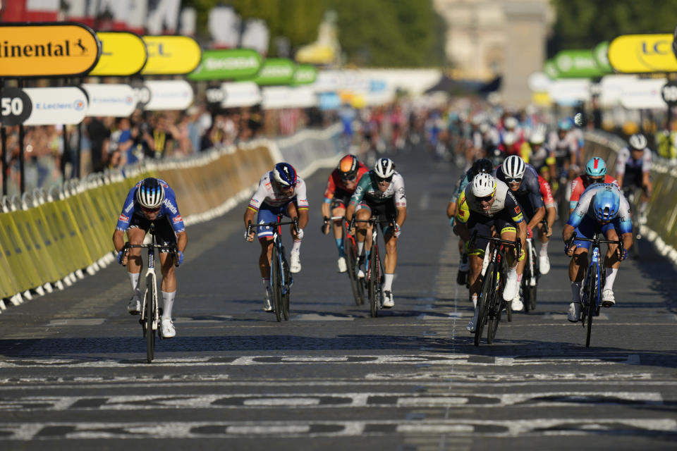 Stage winner Belgium's Jasper Philipsen, left, crosses the finish line ahead of second place Netherlands' Dylan Groenewegen, far right, and third place Norway's Alexander Kristoff, second right, during the twenty-first stage of the Tour de France cycling race over 116 kilometers (72 miles) with start in Paris la Defense Arena and finish on the Champs Elysees in Paris, France, Sunday, July 24, 2022. (AP Photo/Daniel Cole)