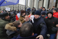 Protesters argue with pro-government people dressed in black, right, during a rally in downtown Minsk, Belarus, Saturday, Dec. 7, 2019. Several hundreds demonstrators gathered to protest against closer integration with Russia. (AP Photo/Sergei Grits)