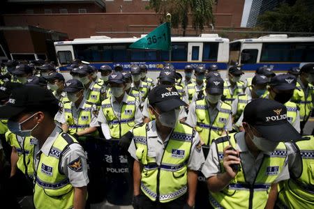 Policemen wearing masks to prevent contracting Middle East Respiratory Syndrome (MERS) stand guard in front of Japanese Embassy in Seoul, South Korea, June 22, 2015. REUTERS/Kim Hong-Ji