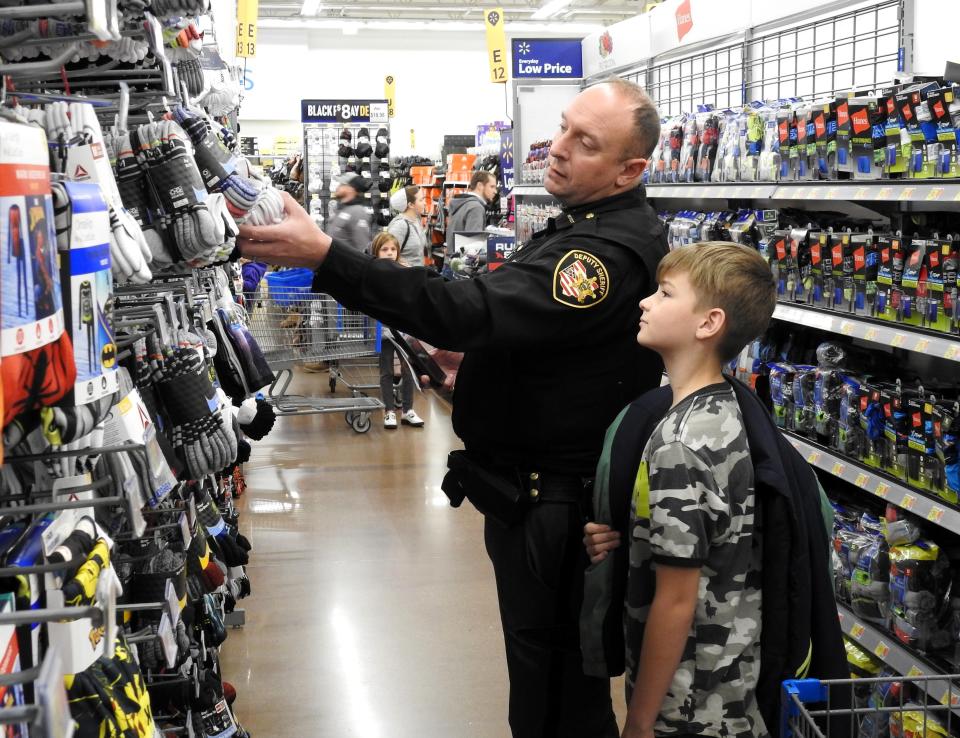 Deputy Josh Walsh of the Coshocton County Sheriff's Office picks out socks with Micah Van Alstyne, 10, for the Coshocton Salvation Army Christmas Castle program at the Coshocton Walmart. This year, the sheriff's office tied a formal Shop with a Cop program into it, even though officers have shopped with youth in the past.