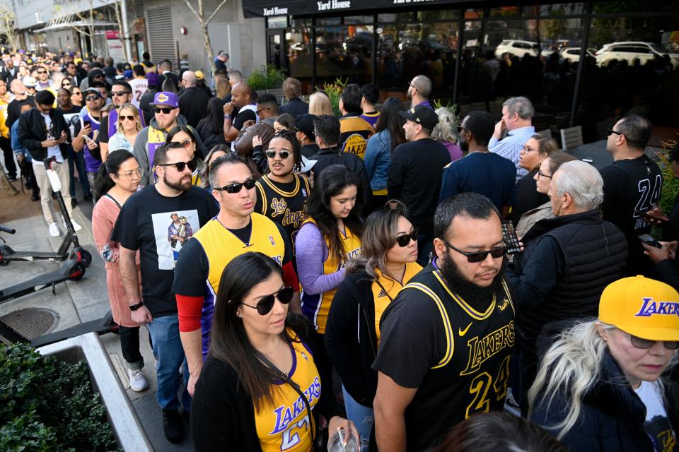 Fans wait in line near the Staples Center before a public memorial for former Los Angeles Lakers star Kobe Bryant and his daughter, Gianna, in Los Angeles, Monday, Feb. 24, 2020. (AP Photo/Kelvin Kuo)