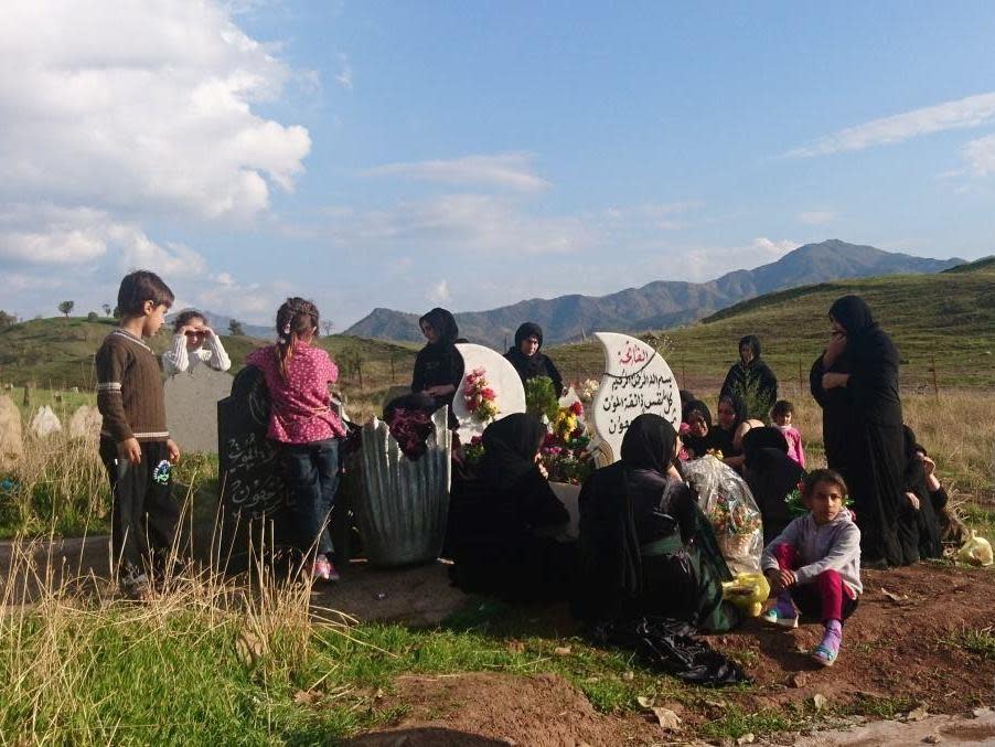 Family mourning Himdat Osman Darwish – a Kurdish villager killed during a bombing – by his grave: Kathleen Kern