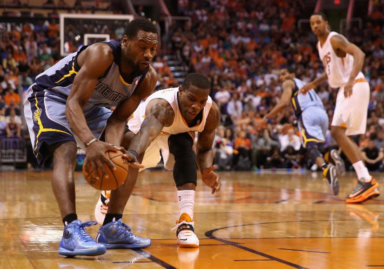 Tony Allen of the Memphis Grizzlies and Eric Bledsoe of the Phoenix Suns reach for a loose ball during the second half of the NBA game at US Airways Center on April 14, 2014 in Phoenix, Arizona