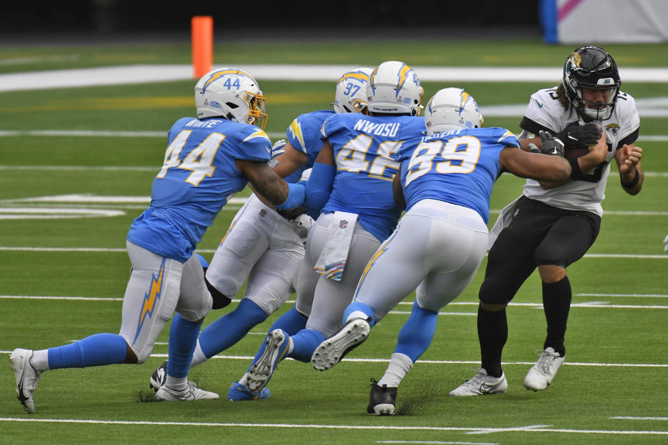 Jacksonville Jaguars quarterback Gardner Minshew, right, is brought down by a group of Los Angeles Chargers defenders during the first half of an NFL football game Sunday, Oct. 25, 2020, in Inglewood, Calif. (AP Photo/Kyusung Gong)