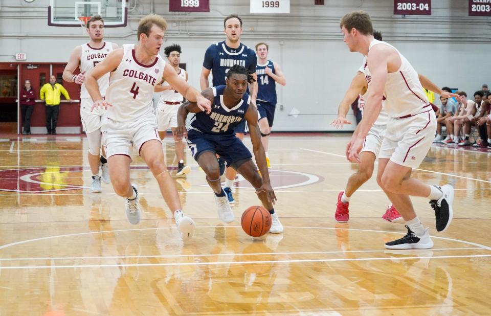 Monmouth guard Myles Ruth drives against a pair of Colgate defenders on Nov. 11, 2022 in Hamilton, New York