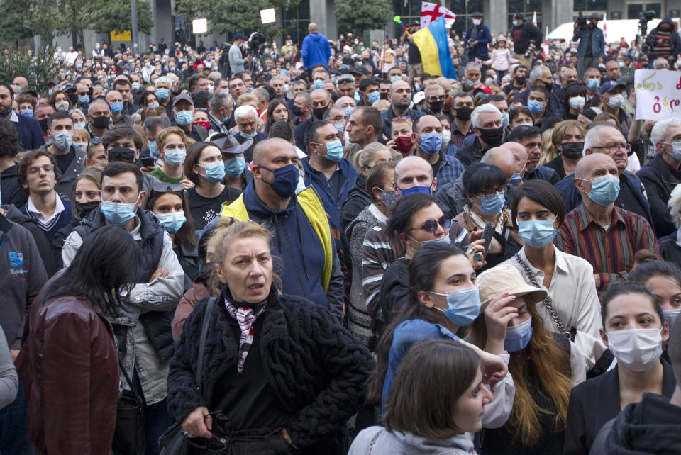 Supporters of the ex-President Mikhail Saakashvili's United National Movement, most of them wearing face masks to help curb the spread of the coronavirus, listen to a speaker during a rally to protest the election results in front of the parliament's building in Tbilisi, Georgia, Sunday, Nov. 1, 2020. Preliminary election results show that Georgia's ruling party won the country's highly contested parliamentary election, but the opposition have refused to recognize Sunday's results, saying they were manipulated. (AP Photo/Shakh Aivazov)