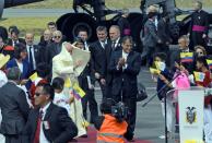 Pope Francis (C) walks next to Ecuadorean President Rafael Correa upon arrival at the airport in Quito on July 5, 2015