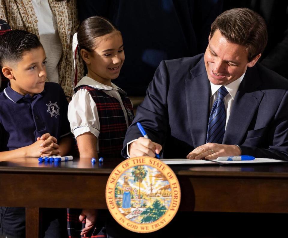 Florida Gov. Ron DeSantis signs HB1 to expand taxpayer-funded school vouchers across Florida during a press conference at Christopher Columbus High School on Monday, March 27, 2023, in Miami, Fla.