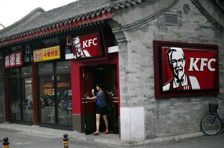 A woman holding an ice cream walks out of a KFC restaurant in Beijing July 17, 2014. REUTERS/Kim Kyung-Hoon