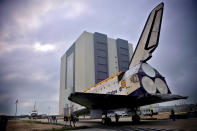 Space Shuttle Endeavour (R), leaving the Orbiter Processing Facility on its way to the Vehicle Assembly Building (VAB), passes Space Shuttle Discovery at Kennedy Space Center August 11, 2011 in Cape Canaveral, Florida. Space Shuttles Endeavour and Discovery switched buildings as they are being decommissioned with the end of the Shuttle program. (Photo by Roberto Gonzalez/Getty Images)