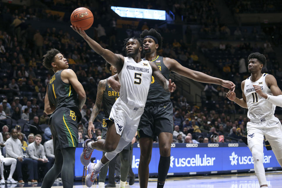 West Virginia guard Joe Toussaint (5) shoots while defended by Baylor forward Flo Thamba (0) during the second half of an NCAA college basketball game in Morgantown, W.Va., Wednesday, Jan. 11, 2023. (AP Photo/Kathleen Batten)