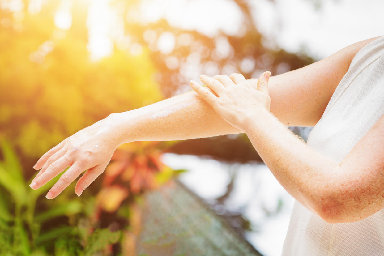 Arms of someone standing just offscreen, one hand touching their forearm.