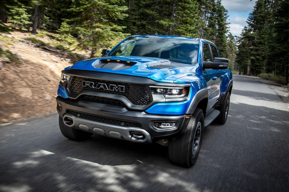 A blue 2021 Ram 1500 TRX pickup truck driving down the road