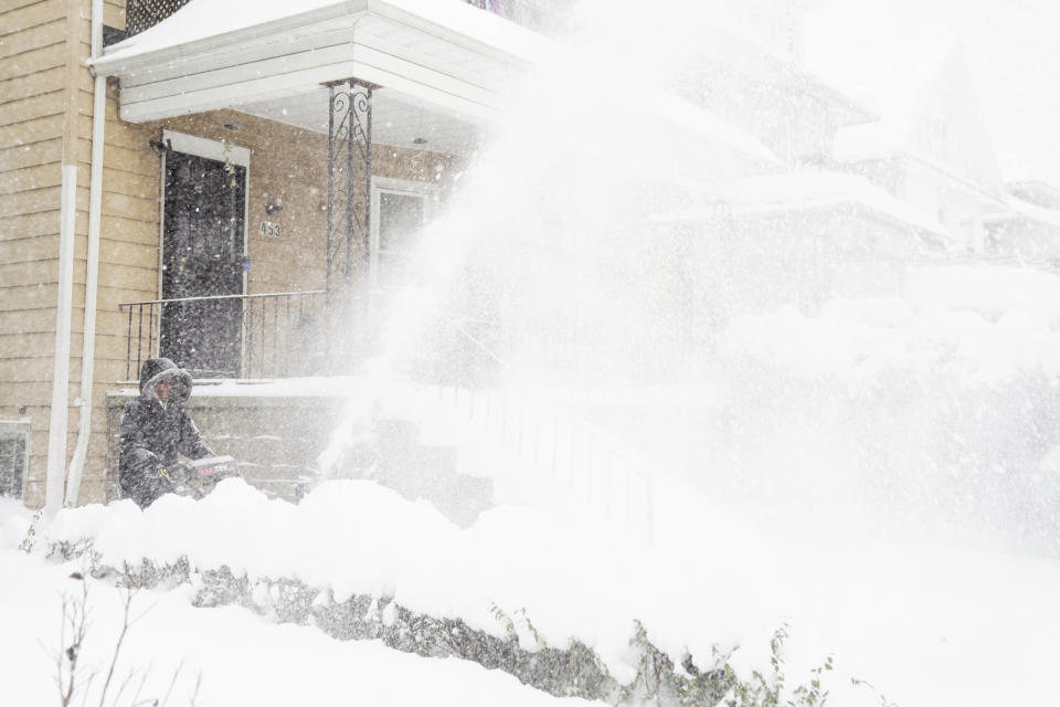 Star Haynes clears snow from her driveway with a snowblower, Saturday, Nov. 19, 2022 in Buffalo, N.Y. Residents of northern New York state are digging out from a dangerous lake-effect snowstorm that had dropped nearly 6 feet of snow in some areas and caused three deaths. The Buffalo metro area was hit hard, with some areas south of the city receiving more than 5 feet by early Saturday. (Libby March /The Buffalo News via AP)