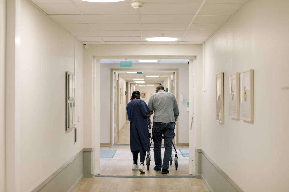 A nurse walking with a patient in a hallway