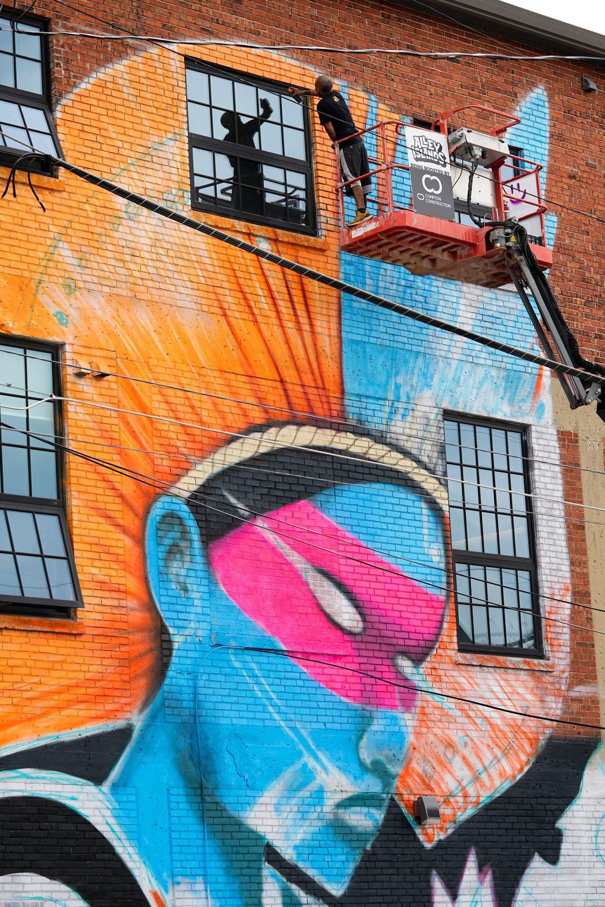 Carlos Roa of the South Side paints a three-story mural in the alley of Lafayette Street, between Fourth Street and Grant Avenue, in preparation for the Alley Islands Street festival, organized by Blockfort Gallery and Studios. The Discovery District festival is to feature live music and other performances, vendors, food and artists Saturday from noon to 10 p.m.