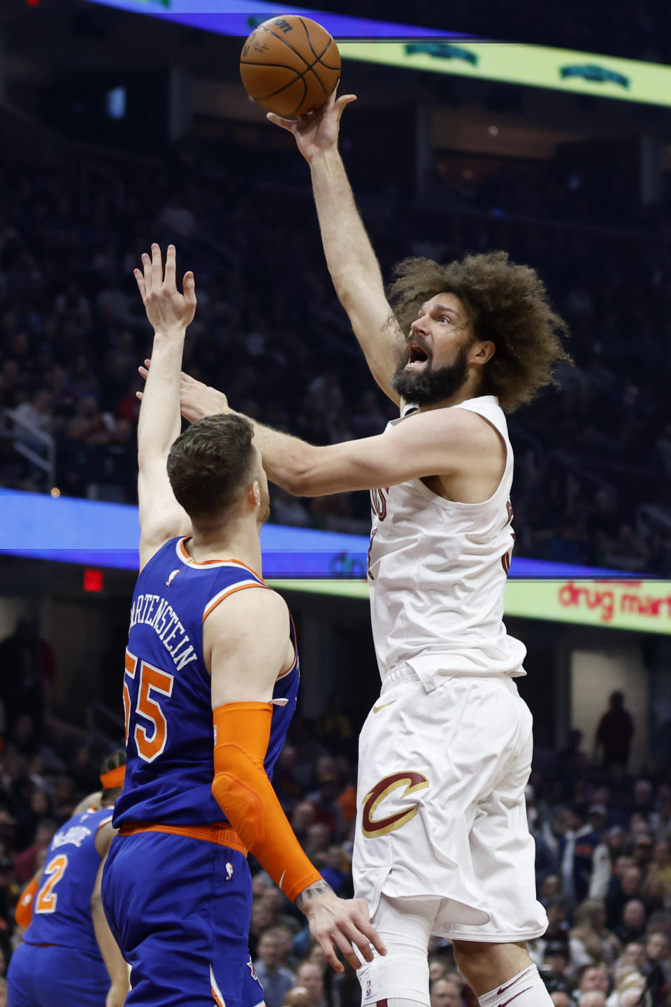 Cleveland Cavaliers center Robin Lopez shoots against New York Knicks center Isaiah Hartenstein (55) during the first half of an NBA basketball game Friday, March 31, 2023, in Cleveland. (AP Photo/Ron Schwane)