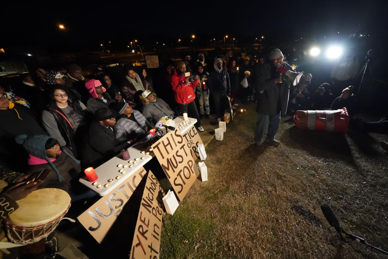 Rev. Andre E Johnson, of the Gifts of Life Ministries, preaches at a candlelight vigil for Tyre Nichols, who died after being beaten by Memphis police officers, in Memphis, Tenn., Thursday, Jan. 26, 2023. Behind him, seated center, are Tyre's mother RowVaughn Wells and his stepfather Rodney Wells. (AP Photo/Gerald Herbert)