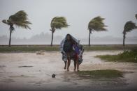 <p>A woman and child use a blanket as protection from wind and rain as they walk in Caibarien, Cuba, Friday, Sept. 8, 2017. Hurricane Irma battered Cuba on Saturday with deafening winds and unremitting rain, pushing seawater inland and flooding homes before taking aim at Florida. Early Saturday, the hurricane center said the storm was centered about 10 miles (15 kilometers) northwest of the town of Caibarien. (Photo: Desmond Boylan/AP) </p>