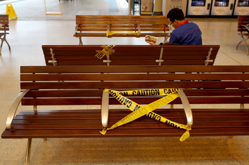 Tape to keep social distancing is seen on the bench, as New South Wales begins shutting down non-essential businesses and moving toward harsh penalties to enforce self-isolation to avoid the spread of coronavirus disease (COVID-19), in Sydney