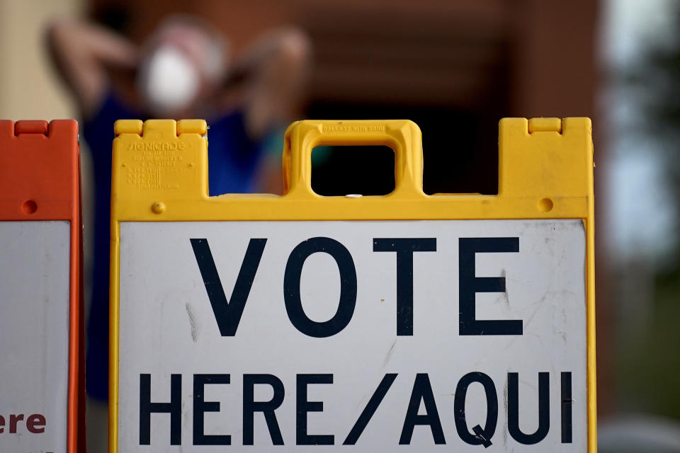 A poll observer stretches outside a polling station on Election Day, early, Tuesday, Nov. 3, 2020, in Glendale, Ariz. (AP Photo/Matt York)