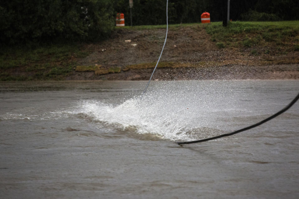 A cable hits the surface of Brays Bayou during Tropical Storm Beta Tuesday, Sept. 22, 2020, in Houston. Beta has weakened to a tropical depression as it parked itself over the Texas coast, raising concerns of extensive flooding in Houston and areas further inland. (Marie D. De Jesus/Houston Chronicle via AP)