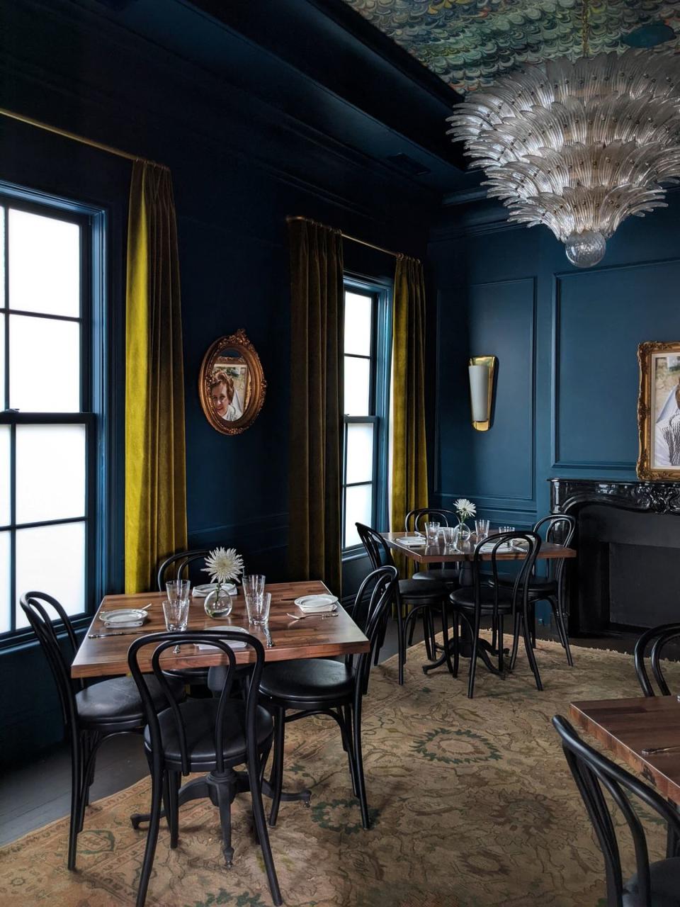 dining room with dark blue walls and gold curtains