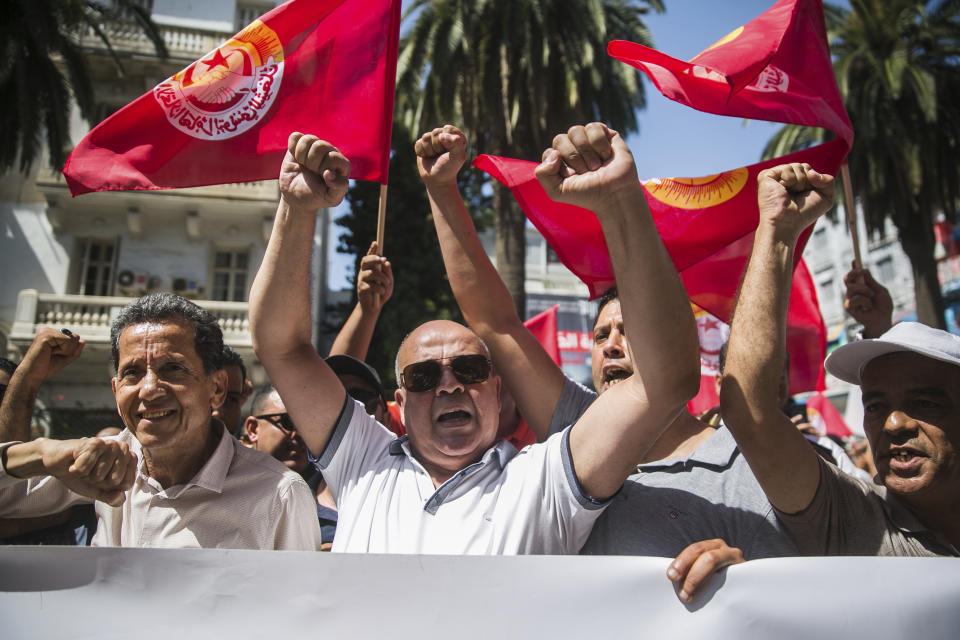 Supporters of the Tunisian General Labor Union (UGTT) gather during a rally outside its headquarters in Tunis, Tunisia, Thursday, June 16, 2022. A nationwide public sector strike in Tunisia is poised to paralyze land and air transportation and other vital activities Thursday with the North African nation already in the midst of a deteriorating economic crisis. (AP Photo/Hassene Dridi)