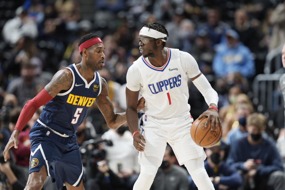 Los Angeles Clippers guard Reggie Jackson, right, looks to pass the ball as Denver Nuggets forward Will Barton defends in the first half of an NBA basketball game Wednesday, Jan. 19, 2022, in Denver. (AP Photo/David Zalubowski)