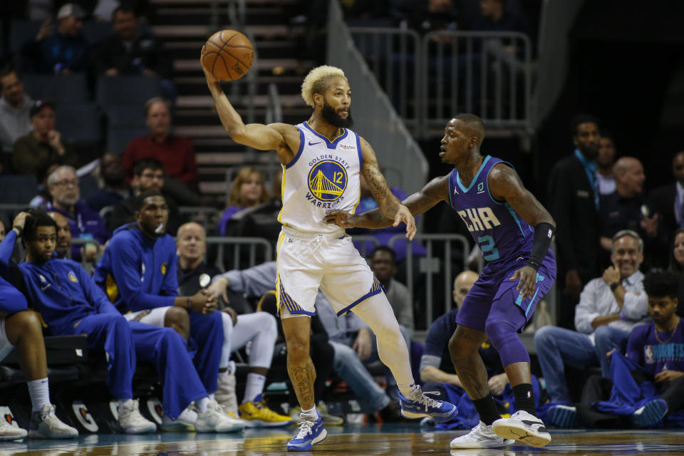 Golden State Warriors guard Ky Bowman, left, passes the ball over Charlotte Hornets guard Terry Rozier during the first half of an NBA basketball game in Charlotte, N.C., Wednesday, Dec. 4, 2019. (AP Photo/Nell Redmond)