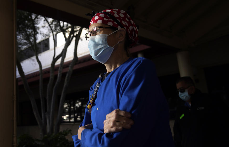 Nurse Teri Wheat walks outside a hospital in Fort Worth, Texas, Thursday, Nov. 19, 2020. As Wheat recently made her rounds at a Texas maternity ward, she began to realize she was having a hard time understanding the new mothers who were wearing masks due to the coronavirus pandemic. Hearing specialists across the U.S. say they have seen an uptick in visits from people like Wheat, who only realized how much they relied on lip reading and facial expressions when people started wearing masks that cover the nose and mouth. (AP Photo/LM Otero)