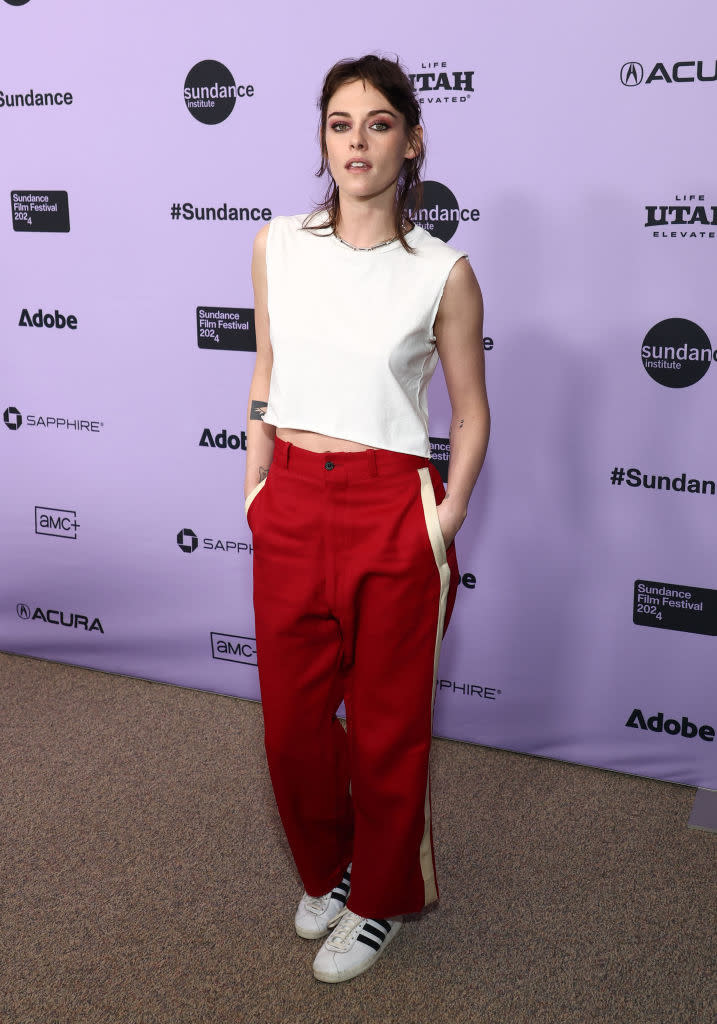 Woman in a white sleeveless top and red trousers poses at Sundance event