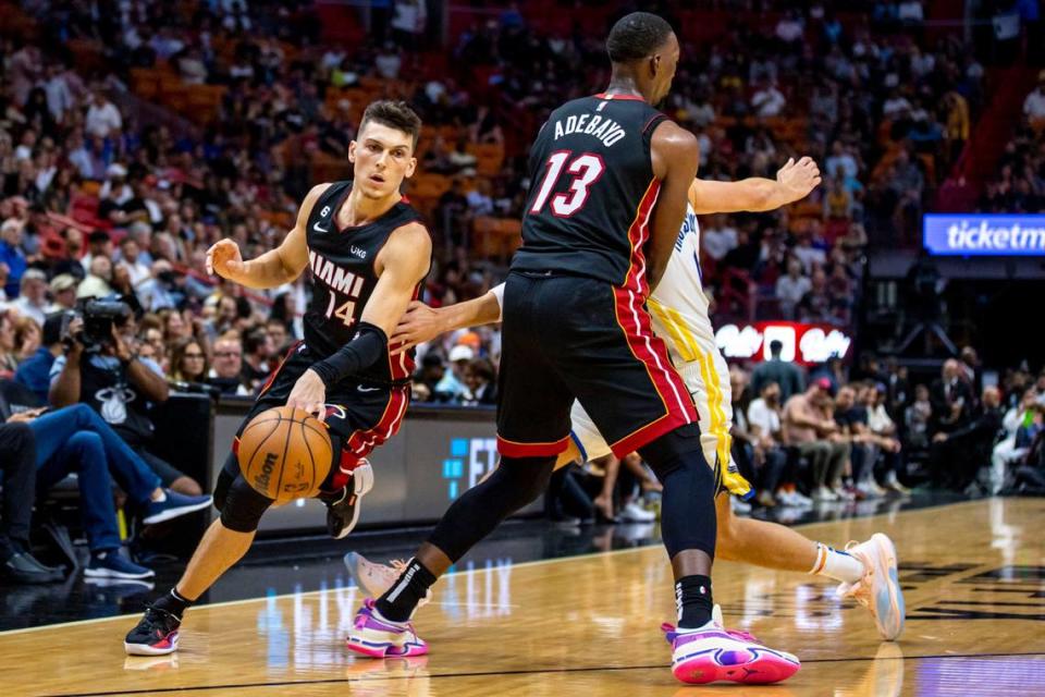 El jugador del Heat Tyler Herro (14) entra al aro con una pantalla de Bam Adebayo sobre Klay Thompson, de los Warriors de Golden State, en el partido celebrado el 1ro de noviembre de 2022 en Miami.